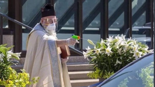 Sacerdote usa una pistola de agua para hacer las bendiciones